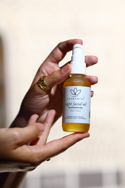 Night Facial Oil by Aromanthi is made with essential oils, rosehip seed and grapeseed oils. The bottle is being held by a woman with a greek byzantine ring